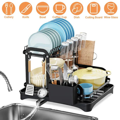 Black 2-tier dish drying rack with drainboard, holding plates, cups, bowls, and utensils.
