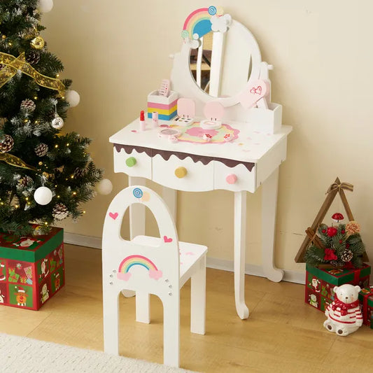 White wooden kids vanity table and chair set with rainbow decor, mirror, 3 drawers, and pretend makeup toys.