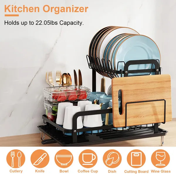 Black 2-tier dish drying rack with drainboard, holding plates, cups, utensils, and a cutting board.