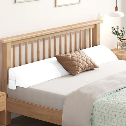 White ergonomic bed gap pillow with side pocket, bridging mattress and wooden headboard.
