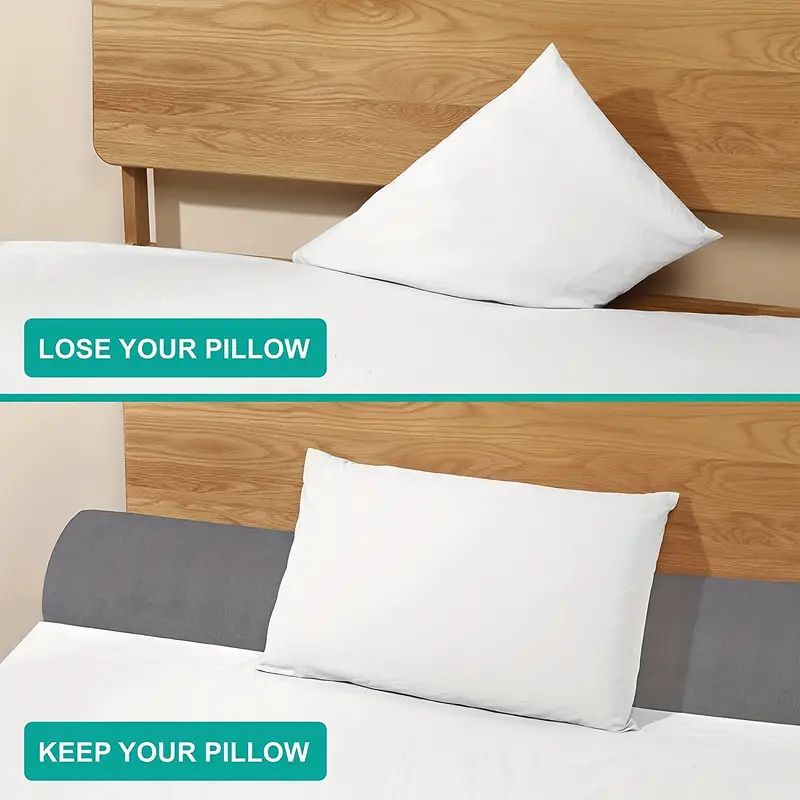 Gray ergonomic bed gap pillow preventing a white pillow from falling between mattress and wooden headboard.