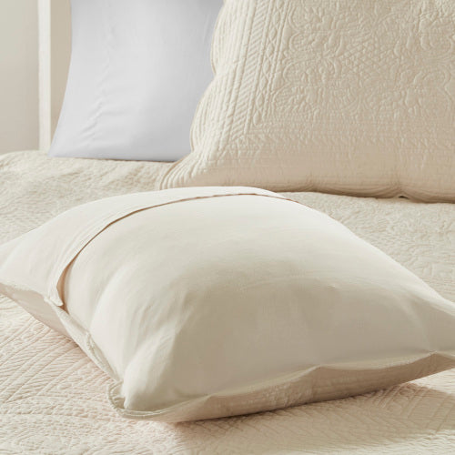 Cream reversible scalloped edge quilt set with quilted texture and solid pillow shams.
