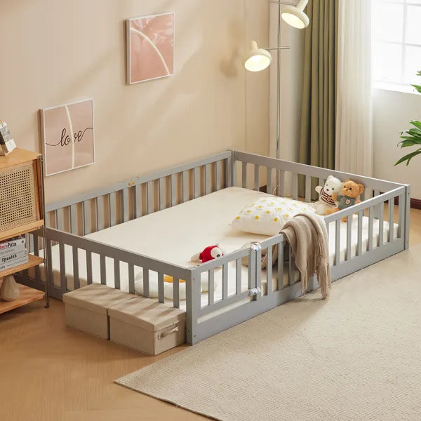 Gray pine wood full-size playpen bed with secure entry door, mattress, and toys in a child's room.