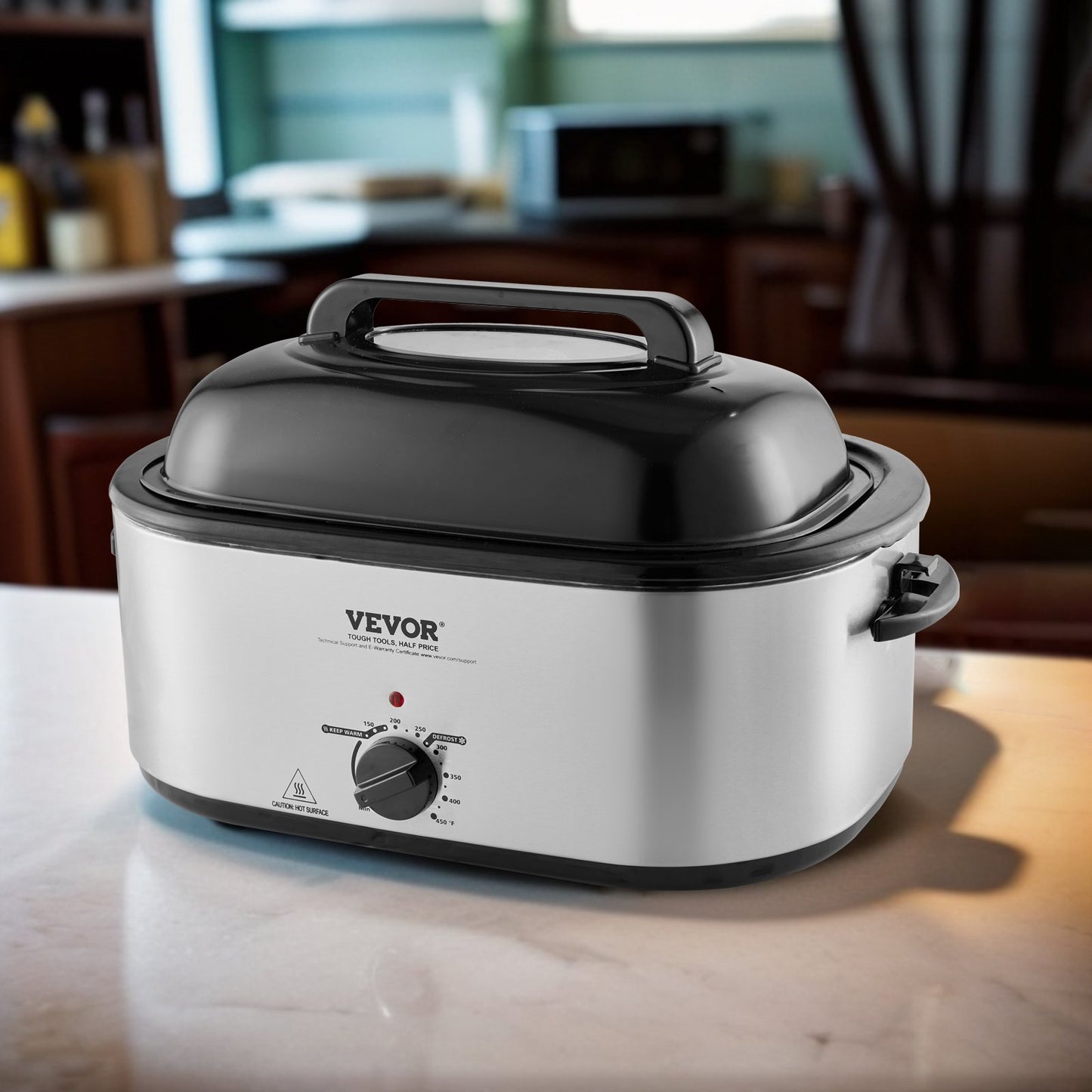 Silver 24QT VEVOR electric roaster oven with black lid and temperature dial on a kitchen counter.