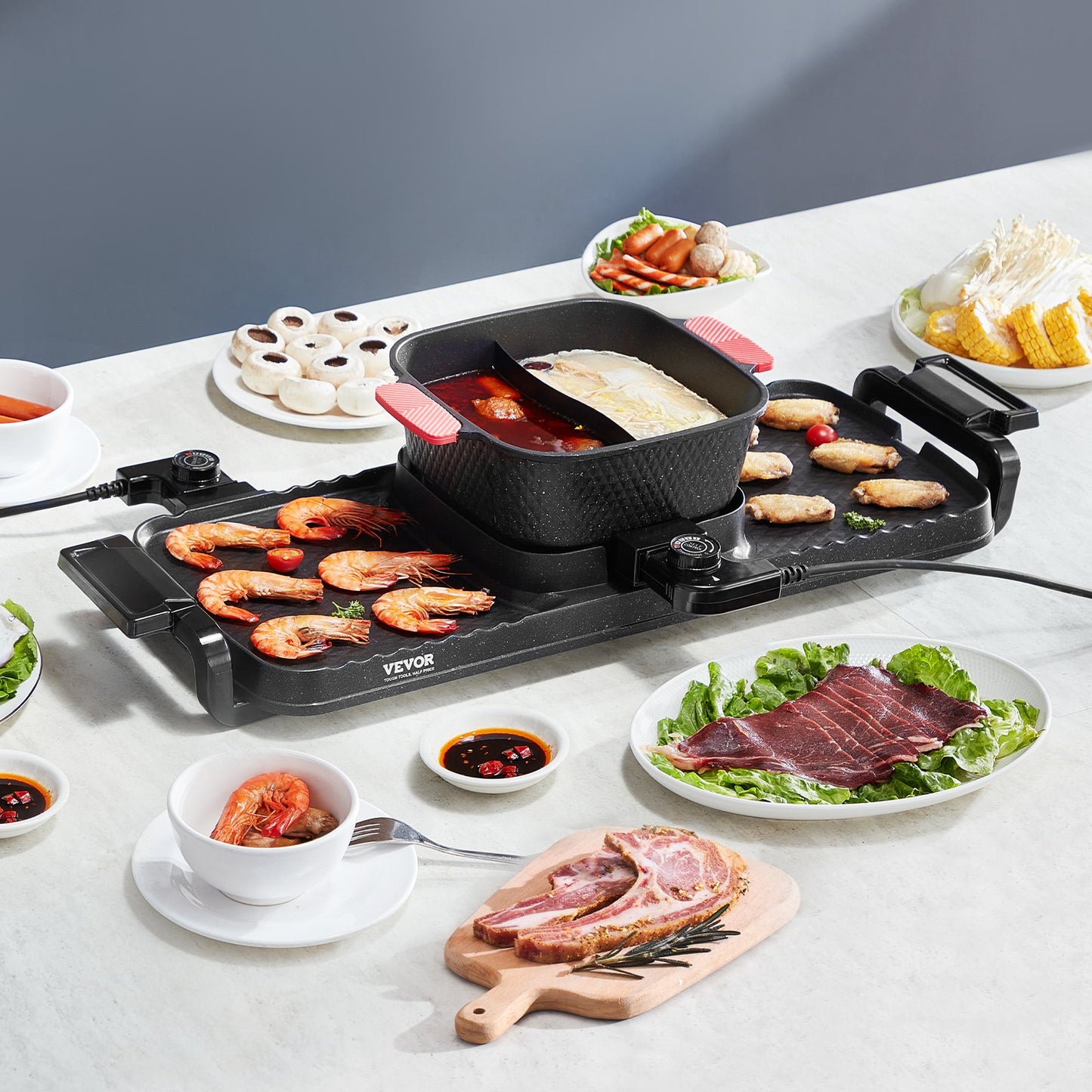 Black 2-in-1 hot pot and smokeless BBQ grill with shrimp, chicken wings, and raw meat cooking on a white table.