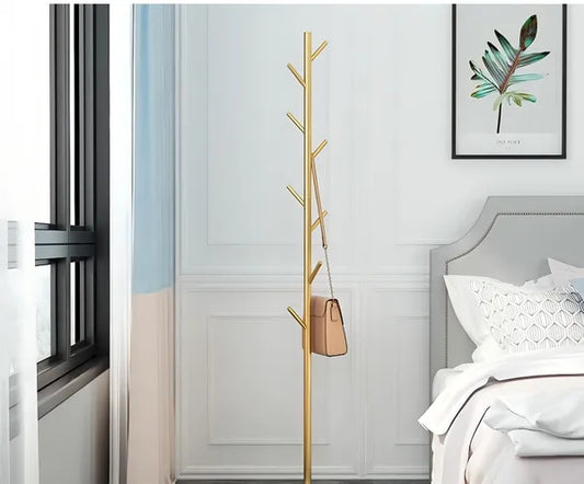 The Golden Aura luxury garment rack with a gold metal frame and faux marble base, holding a brown purse.