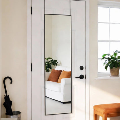 Full-length mirror with slim black aluminum frame hanging over a white door.