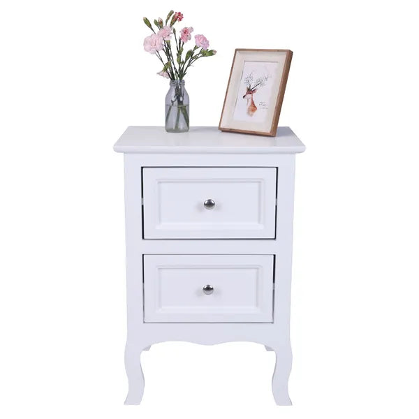White "Heritage Charm" 2-tier nightstand with two drawers, a vase of flowers, and a framed picture.