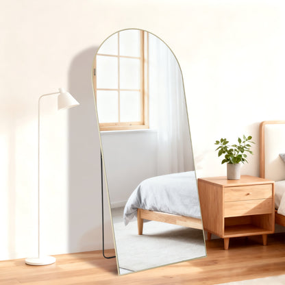 Golden arched full-length standing mirror, 21x56 inch, with a sleek frame in a bedroom setting.