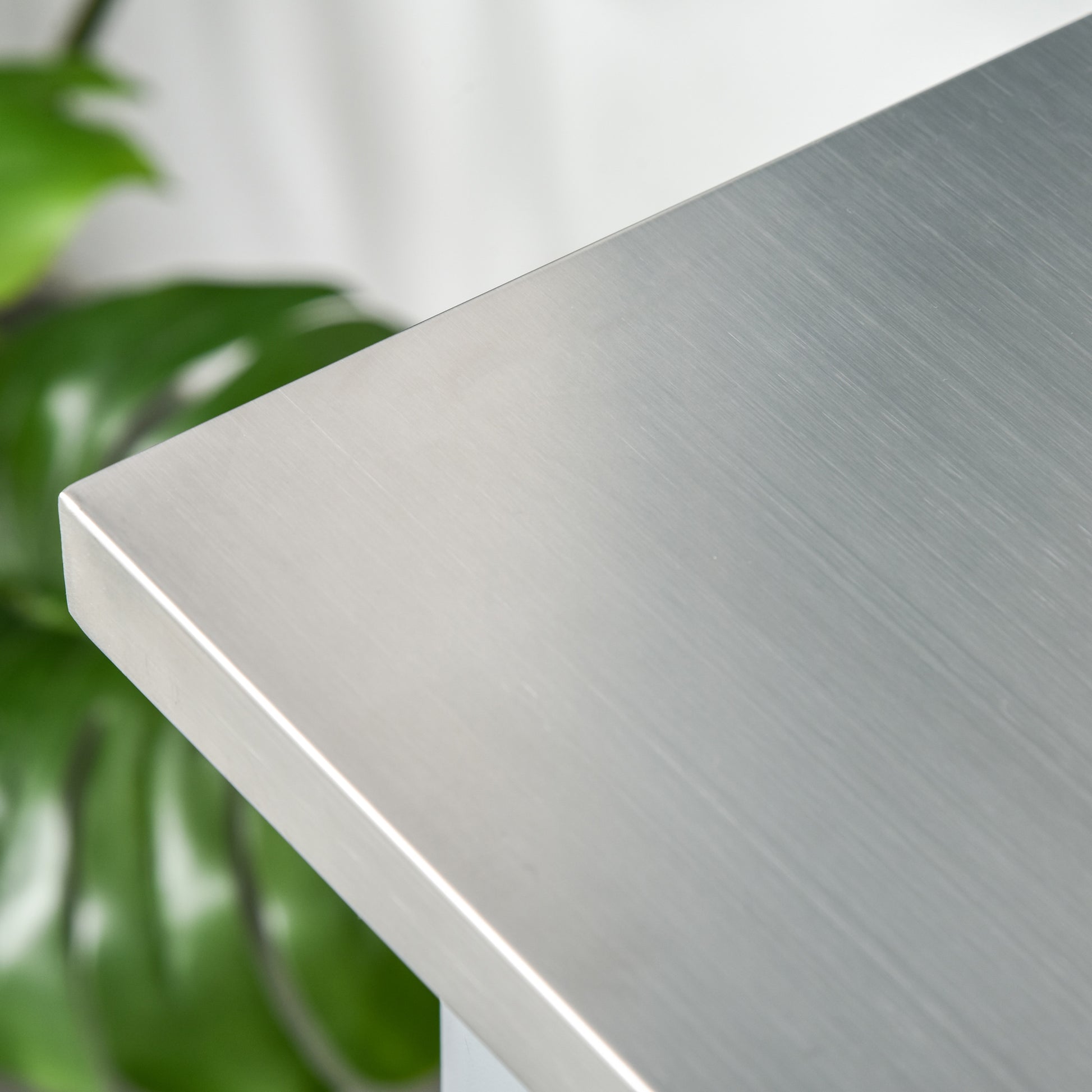 Close-up of a brushed stainless steel kitchen island countertop with a subtle sheen.