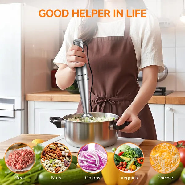 Stainless steel immersion blender in use, with various fresh ingredients shown below.