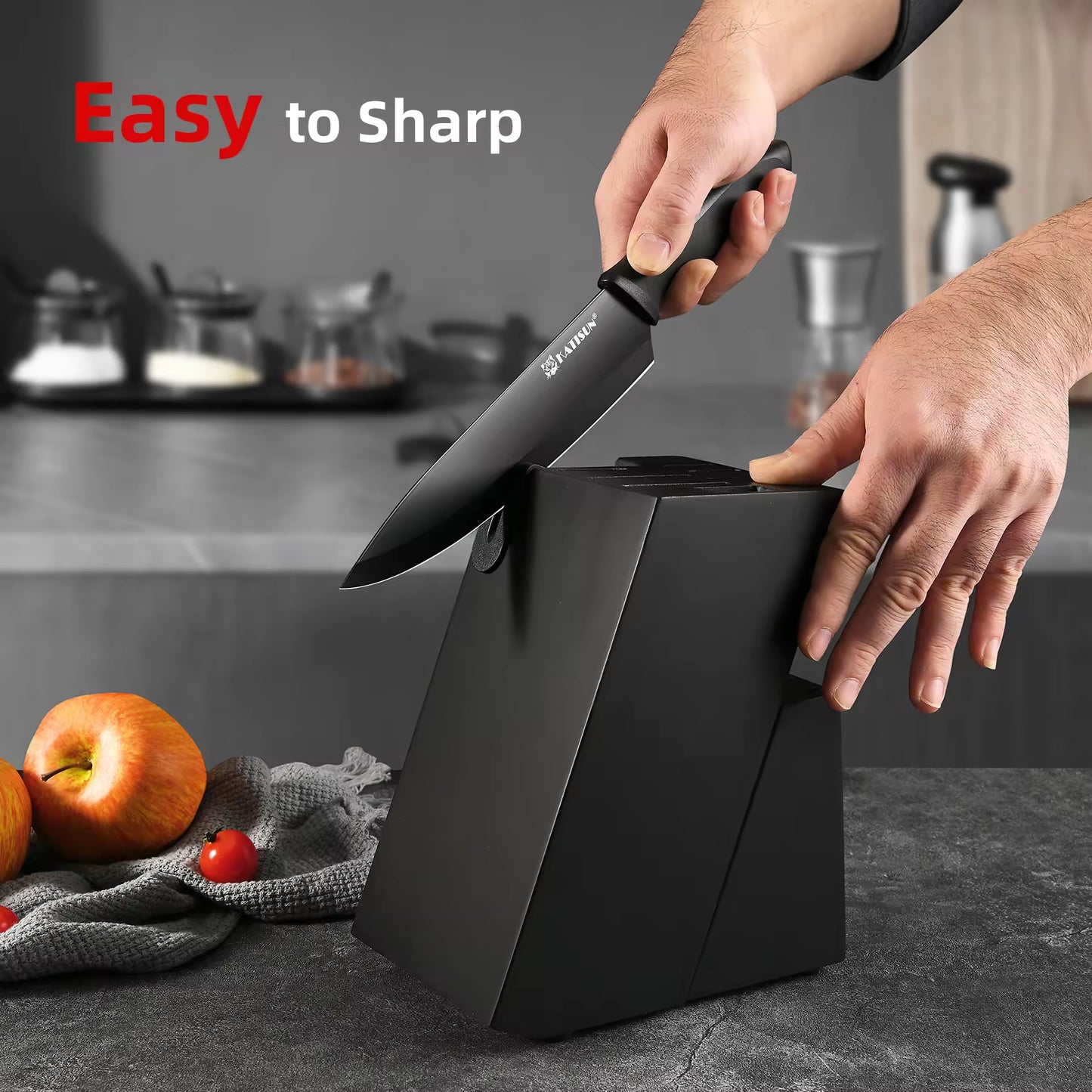 Hands sharpening a black chef knife in a modern black knife block with built-in sharpener.