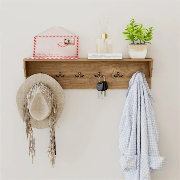 Natural wood wall-mounted coat rack with 6 hooks, a storage shelf, a hat, keys, and a shirt.